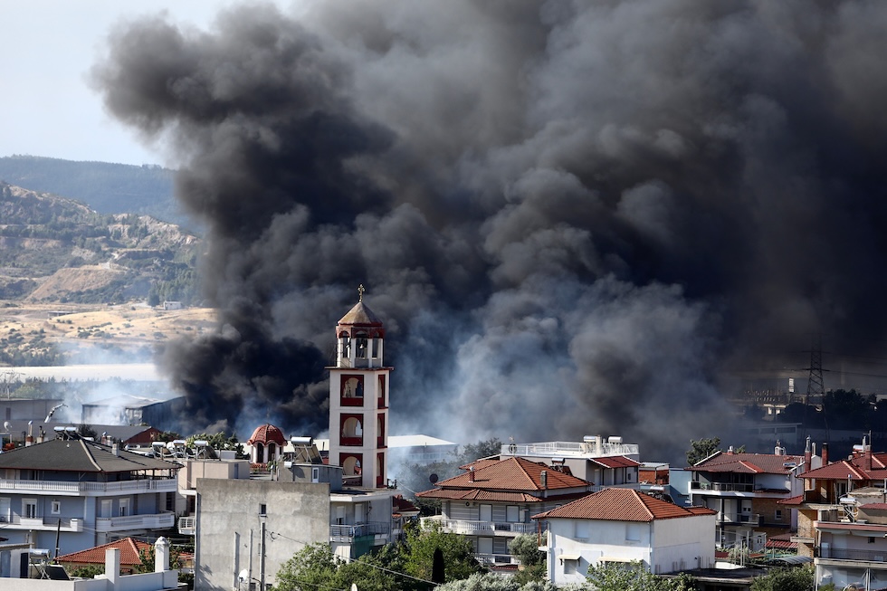 Una nuvola di fumo nera a causa di un incendio che si è sviluppato nella periferia della città (AP Photo/Giannis Papanikos)
