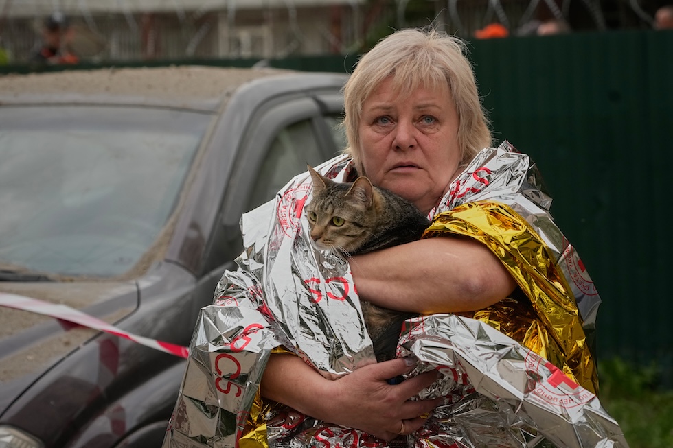 Una donna con il suo gatto fuori da un edificio colpito dai bombardamenti russi (AP Photo/Efrem Lukatsky)