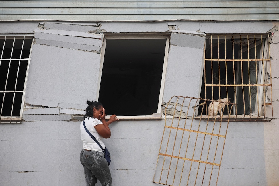 Una donna vicino a un gatto in un edificio danneggiato dai terremoti del 24 giugno (REUTERS/Adriano Machado)