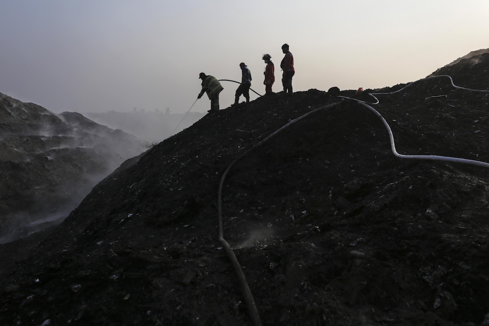 Vigili del fuoco e volontari alle prese con un incendio nella discarica di Jatiwaringin; l'incendio, divampato più di una settimana fa, si è esteso su circa 15 dei 33 ettari della discarica, avvolgendo la zona in una densa coltre di fumo tossico  (EPA/AGOES RUDIANTO via Ansa)
