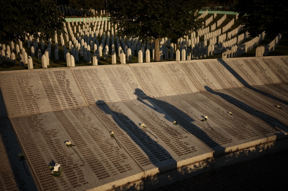 L'ombra di tre persone al monumento con i nomi delle vittime del genocidio di Srebrenica, nel giorno del trentunesimo anniversario. (AP Photo/Armin Durgut)
