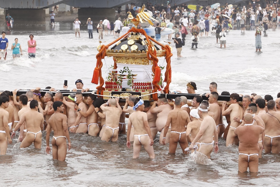 I partecipanti del Enoshima Tenno Festival, vestiti con perizomi tradizionali, portano in mare un mikoshi, un sacro palanchino portatile. (EPA/RODRIGO REYES MARIN)