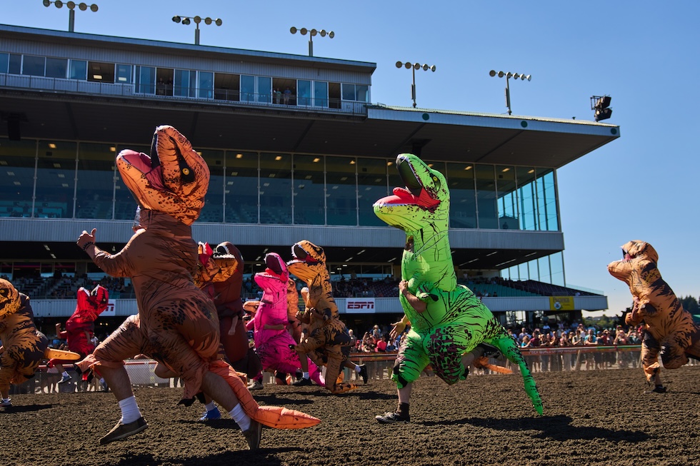 Partecipanti a una gara in cui si corre con costumi gonfiabili da Tyrannosaurus rex (AP Photo/Lindsey Wasson)