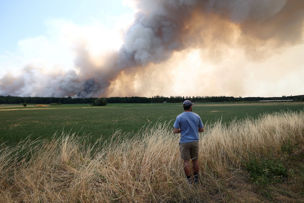 Un uomo guarda un incendio nella foresta di Fontainebleau (REUTERS/Stephane Mahe)