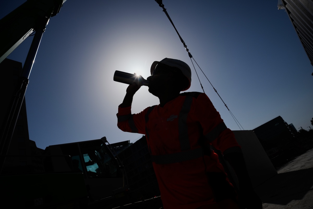Un operaio beve in un cantiere