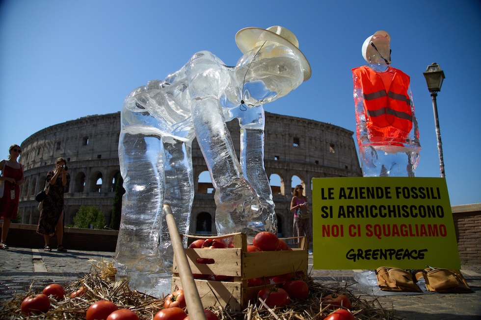 Una statua di ghiaccio raffigurante un contadino, una delle categorie di lavoratori più a rischio a causa dell'aumento delle temperature, davanti al Colosseo di Roma durante una protesta di Greenpeace (AP Photo/Alessandra Tarantino)