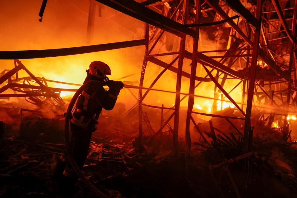 Un vigile del fuoco cerca di spegnere un incendio in un magazzino colpito dai missili russi (REUTERS/Valentyn Ogirenko)