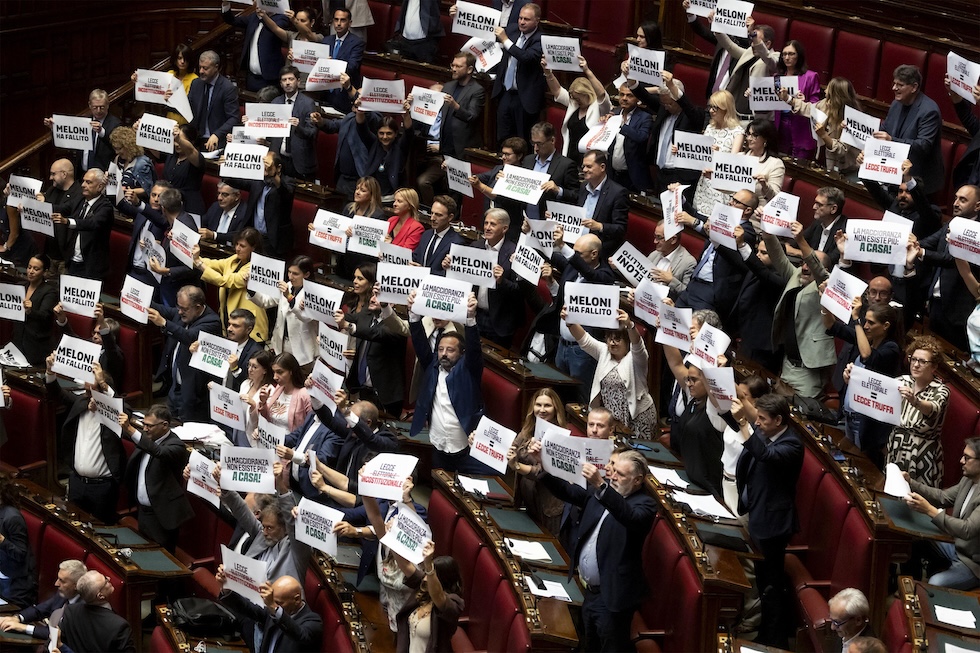 I deputati delle opposizioni mostrano cartelli di protesta subito dopo il voto con cui è stata approvata la legge elettorale alla Camera, clamorosamente priva di un emendamento proposto e fortemente sostenuto da Meloni (ANSA/MASSIMO PERCOSSI)