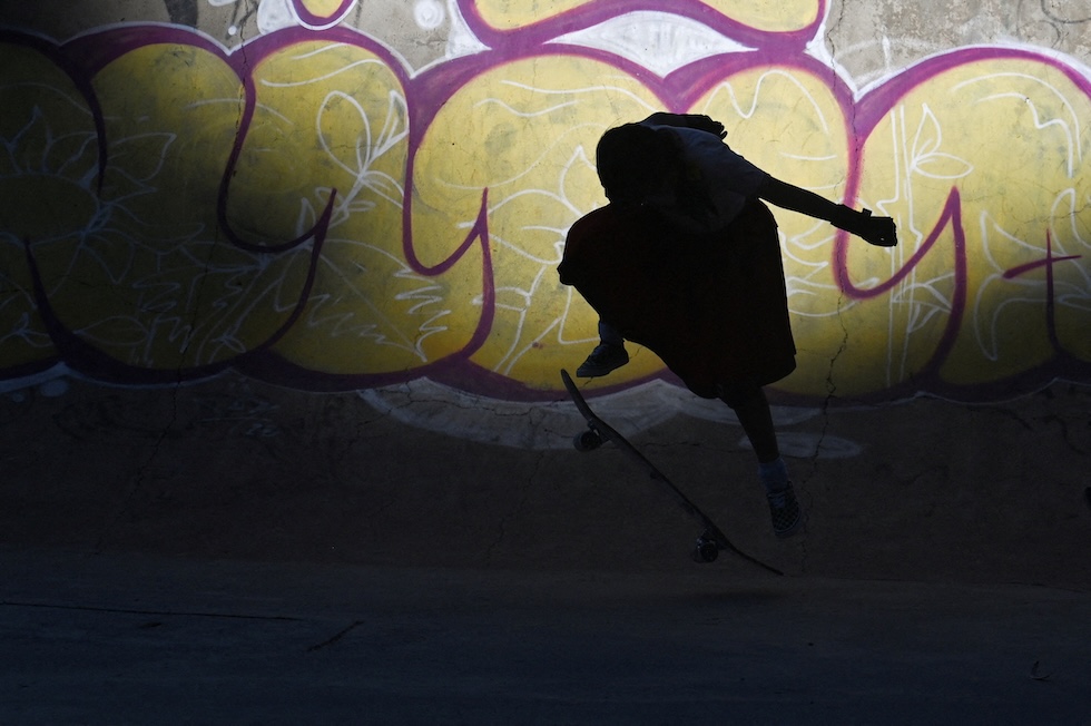 Una donna con indosso il tradizionale abito da Cholita si allena sullo skateboard prima di una gara (REUTERS/Claudia Morales)