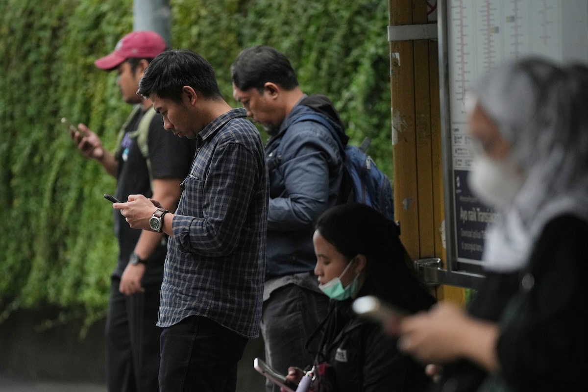 Un gruppo di persone concentrate ognuna sul proprio smartphone