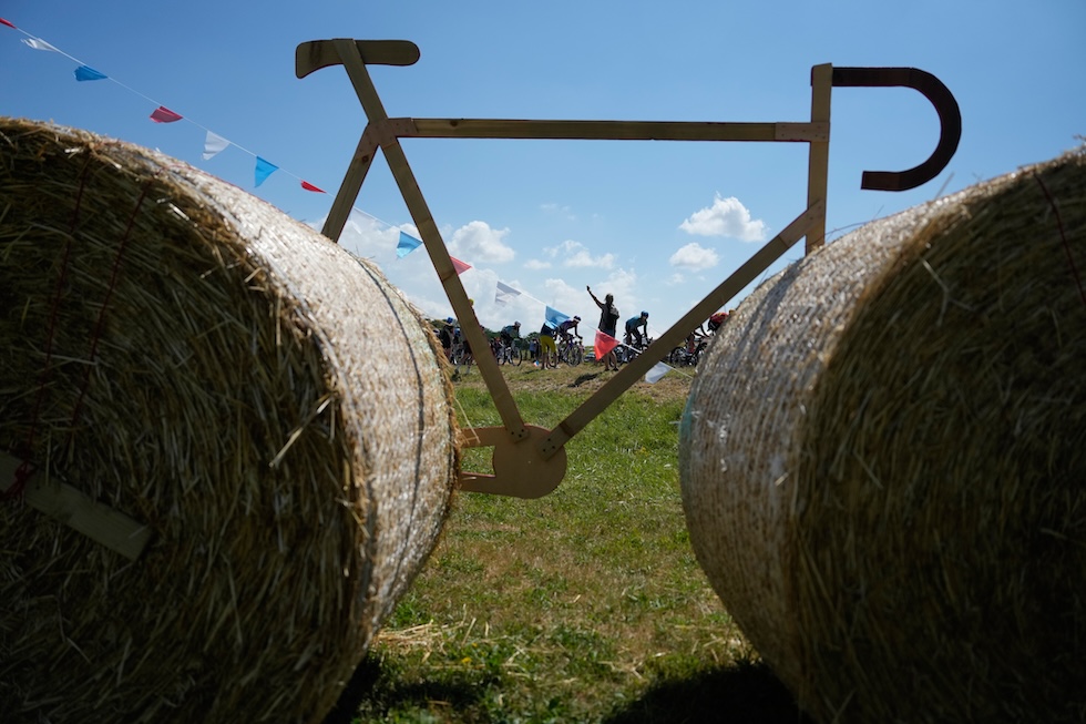 Il passaggio dei ciclisti al Tour de France, visti attraverso due balle di fieno decorate con un finto telaio di cartone a formare una bicicletta, durante la tredicesima tappa da Dole a Belfort (AP Photo/Mosa'ab Elshamy)