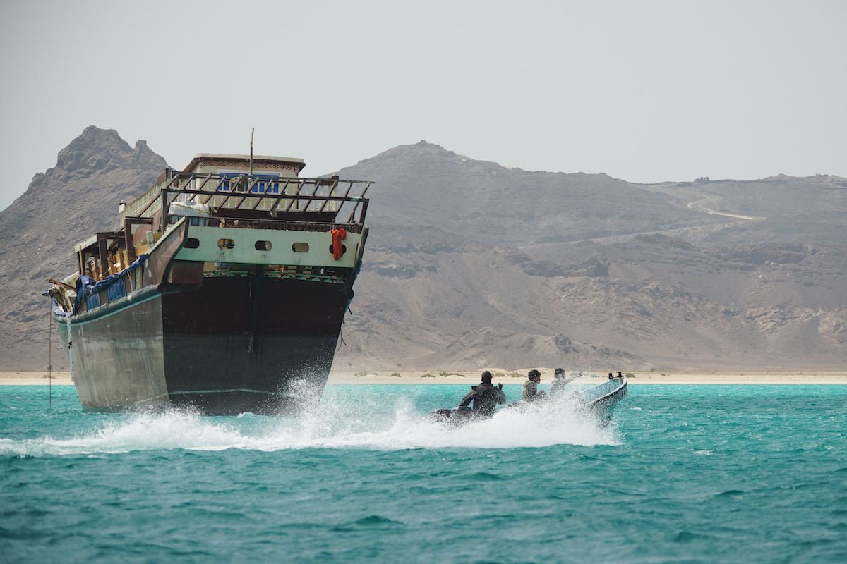Una barca di pescatori passa davanti a una nave commerciale nello stretto di Bab el Mandeb, aprile 2026 (AP Photo/Abdulnasser Alseddik)