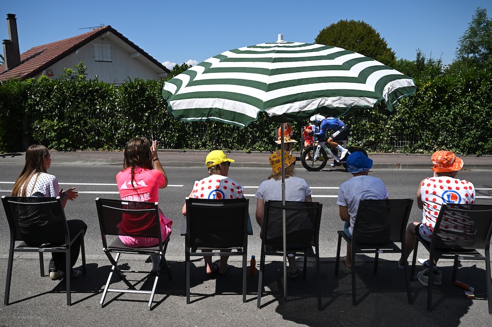 Alcuni spettatori seduti sul ciglio della strada guardano il passaggio del ciclista belga Jonas Rickaert durante il Tour de France (Dario Belingheri/Getty Images)