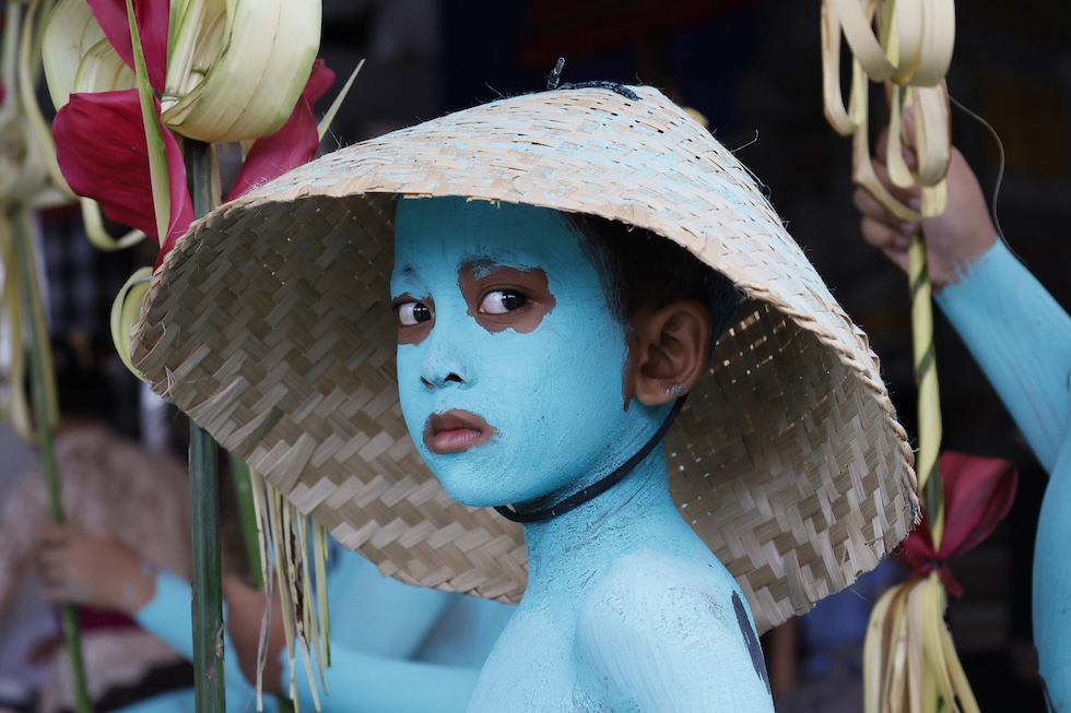Un bambino in abiti tradizionali e con il corpo dipinto durante il rituale Ngerebeg, che serve a scacciare gli spiriti maligni (EPA/MADE NAGI via Ansa)