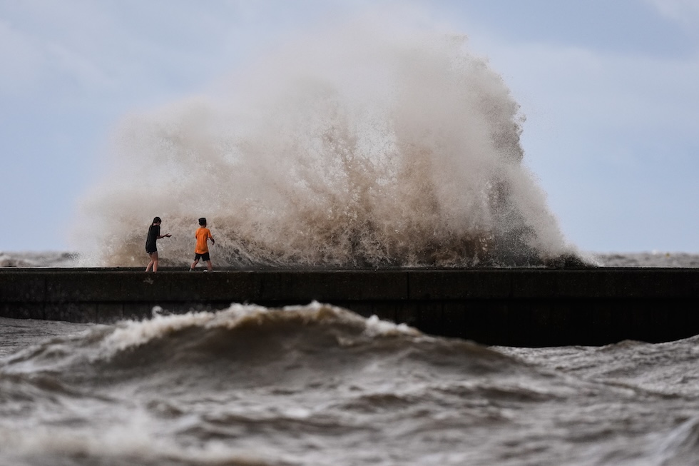 Due bambini vicino alle onde che si infrangono sul molo di West End, sul lago Pontchartrain (AP Photo/Gerald Herbert)