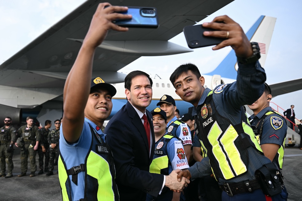 Poliziotti filippini si scattano un selfie all'aeroporto di Manila insieme al segretario di Stato statunitense Marco Rubio, di ritorno negli Stati Uniti dopo un incontro con l’Associazione delle Nazioni del Sud-est asiatico (ASEAN) (Brendan Smialowski/Pool Photo via AP)