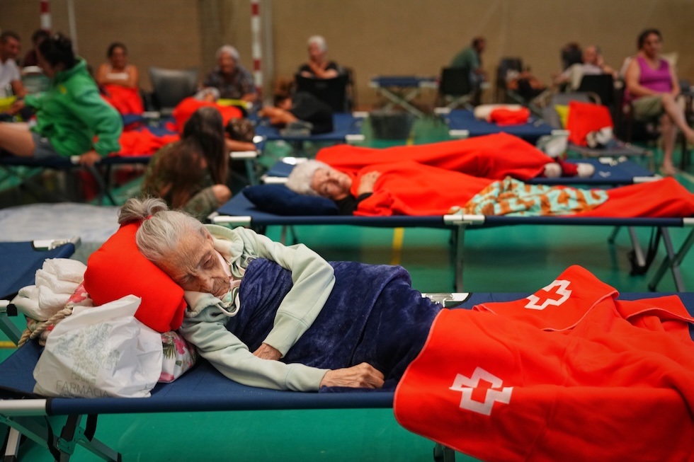 I residenti di un piccolo paese nella Castiglia e León trascorrono la notte in un centro sportivo, dopo essere stati evacuati dalle loro case a causa della minaccia di un incendio boschivo (AP Photo/Manu Fernandez)