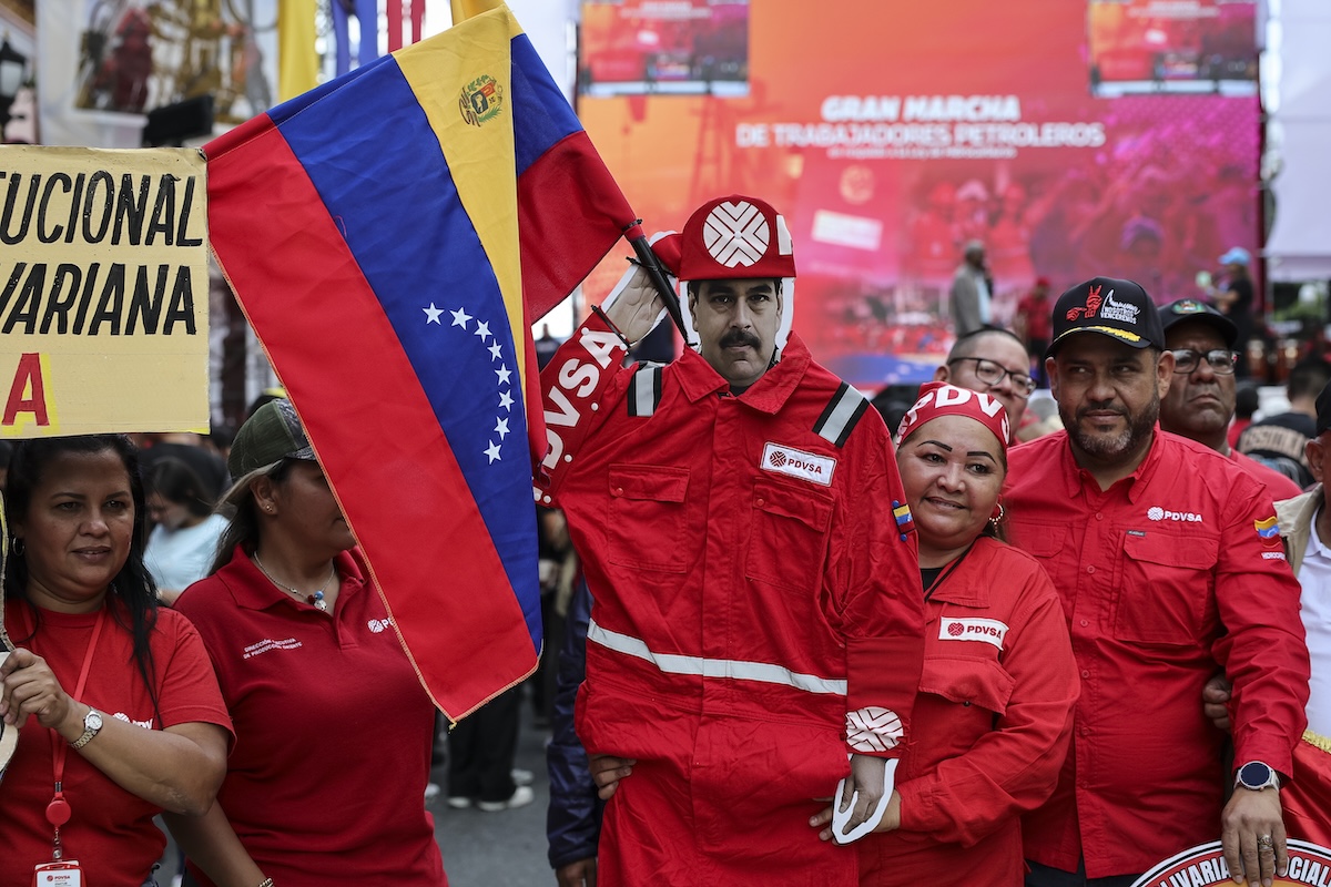 Lavoratori di Petróleos de Venezuela, l'azienda petrolifera statale, con una sagoma di cartone di Maduro durante una manifestazione a Caracas lo scorso 29 gennaio