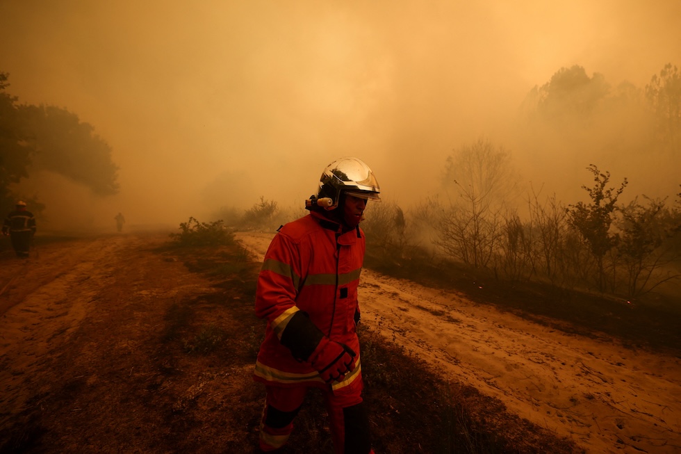 Un vigile del fuoco al lavoro per spegnere gli incendi  (REUTERS/Stephane Mahe)
