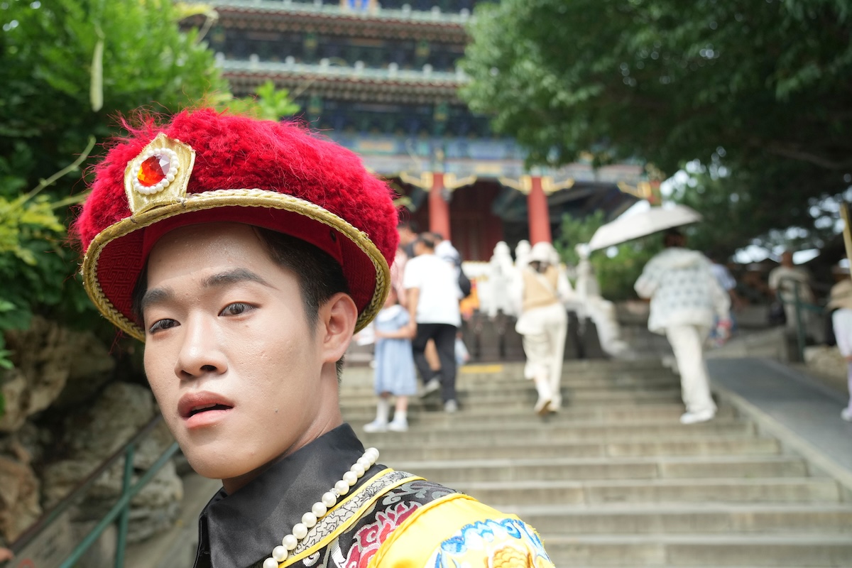 Un uomo vestito con un abito tradizionale cammina vicino alla Città Proibita (AP Photo/Achmad Ibrahim)