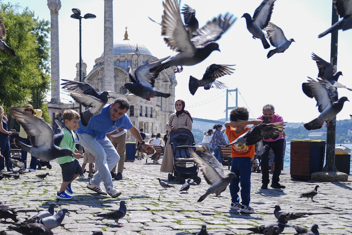 Abitanti e turisti nella piazza davanti alla moschea Ortaköy a Istanbul (Bunyamin Celik/Anadolu via Getty Images)
