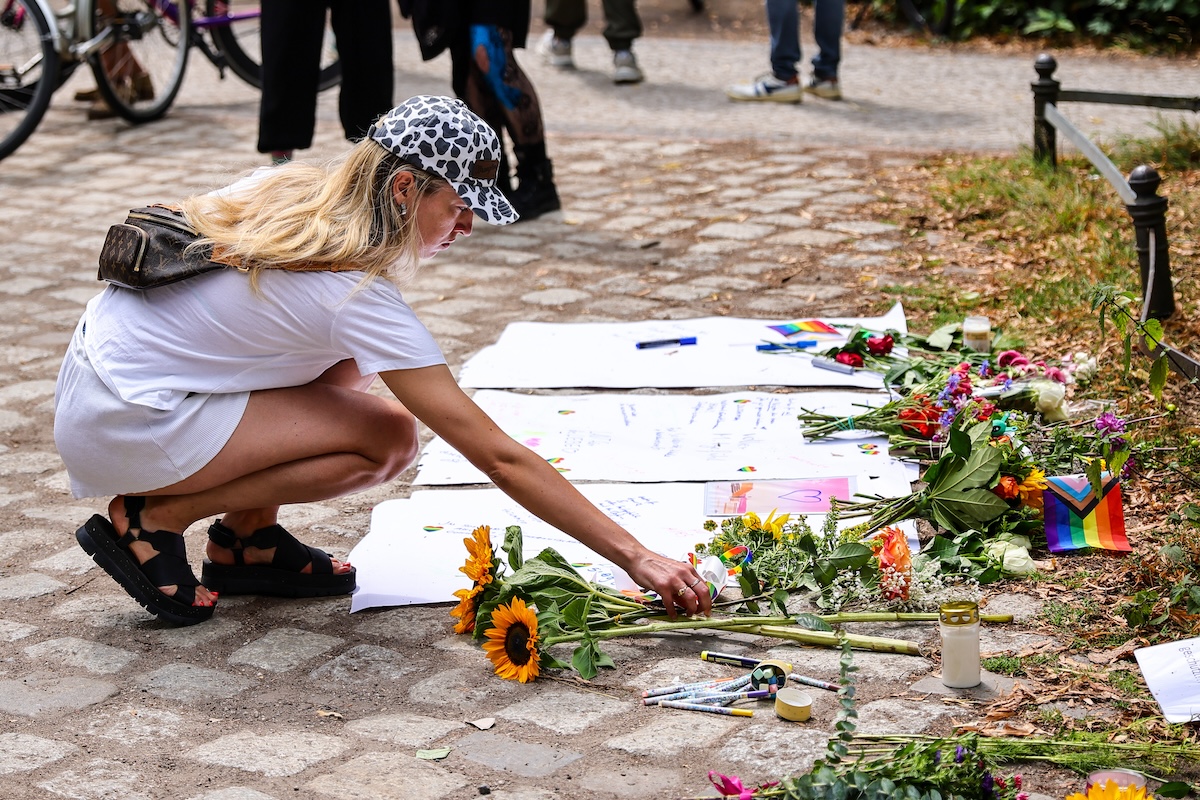 Una donna lascia dei fiori vicino al punto in cui le persone sono state travolte da un'auto sabato sera durante il corteo per il Pride  (Omer Messinger/Getty Images)
