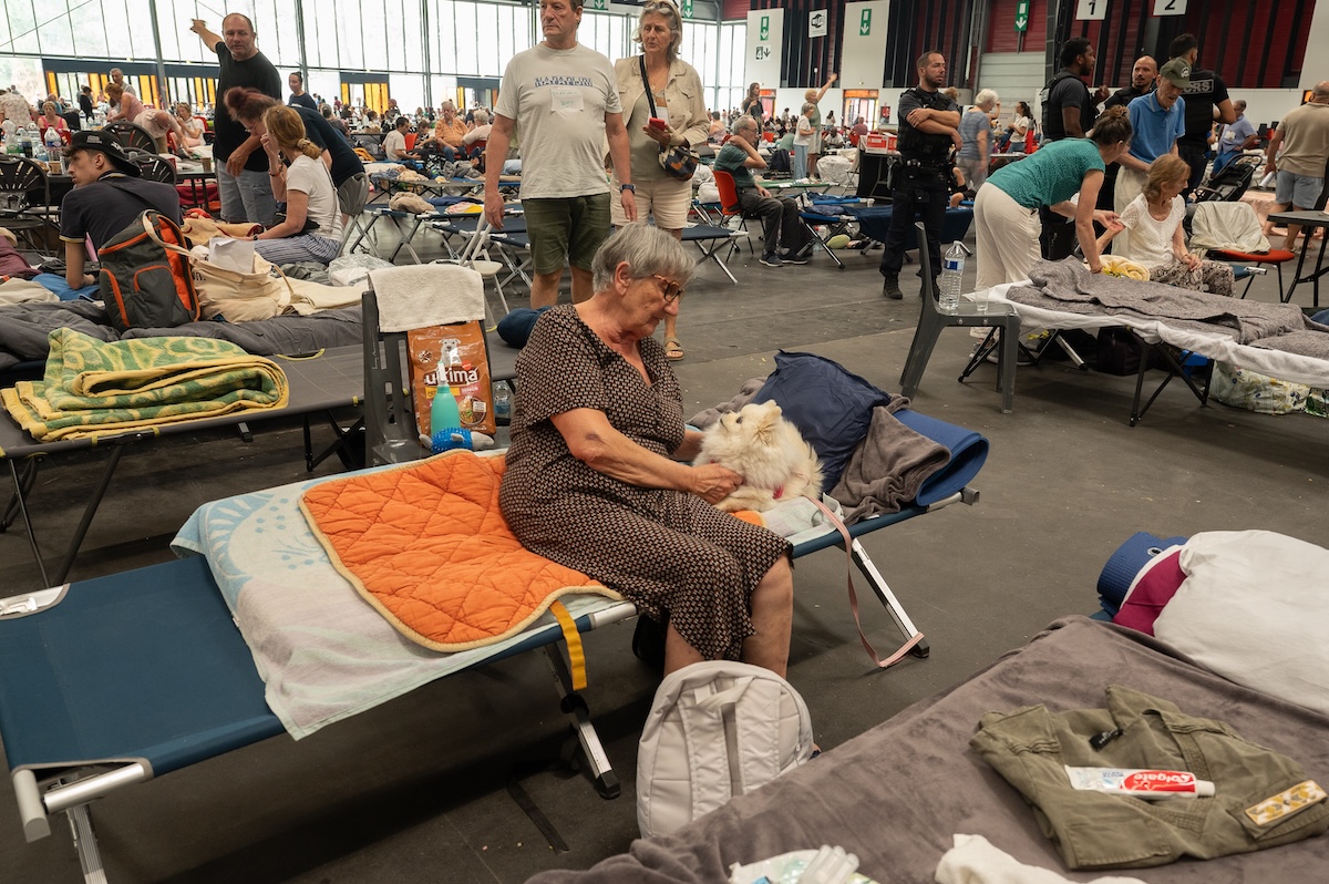 Una donna con il proprio cane in un centro di accoglienza di emergenza allestito a Bordeaux, in Francia, dove sono state ospitate alcune delle centinaia di migliaia di persone evacuate per i devastanti incendi (AP Photo/Caroline Blumberg)