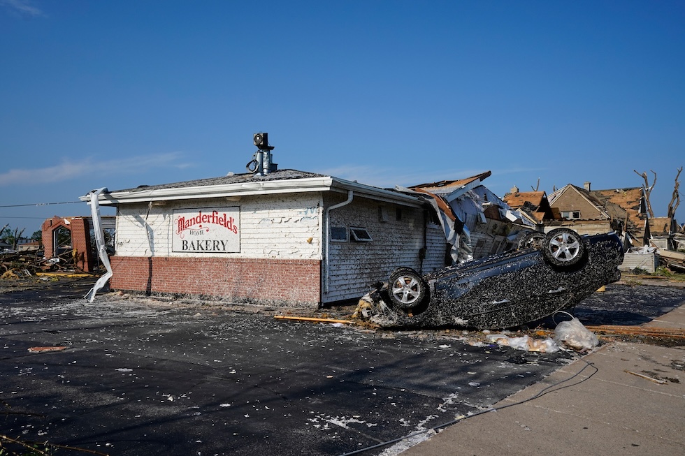 Un'auto capovolta davanti a un panificio danneggiato da un tornado (AP Photo/Kayla Wolf)

