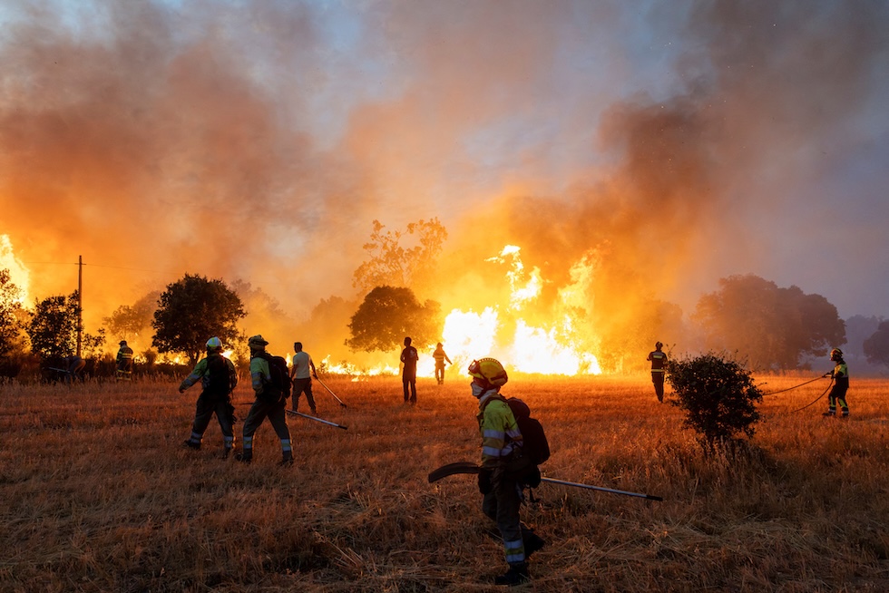 Residenti e vigili del fuoco lavorano per spegnere un incendio boschivo nella provincia di Zamora (REUTERS/Umit Bektas)