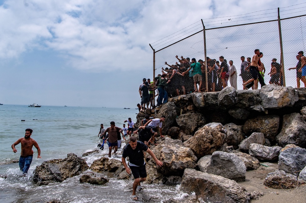 Migranti attraversano il confine tra il Marocco e l’enclave spagnola di Ceuta (AP Photo/Antonio Sempere)