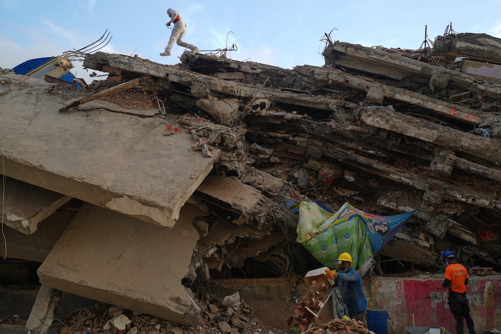 Un uomo rimuove le macerie di un edificio crollato a causa dei terremoti, in cerca del corpo di un parente (AP Photo/Ariana Cubillos)