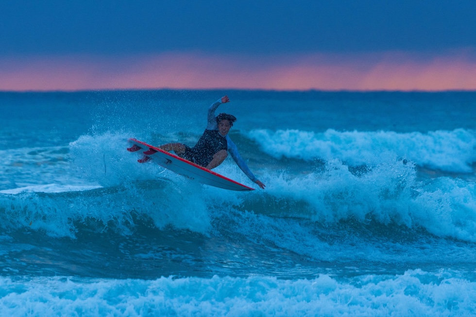 Un surfista cavalca un'onda al tramonto a Cardiff State Beach (REUTERS/Mike Blake)