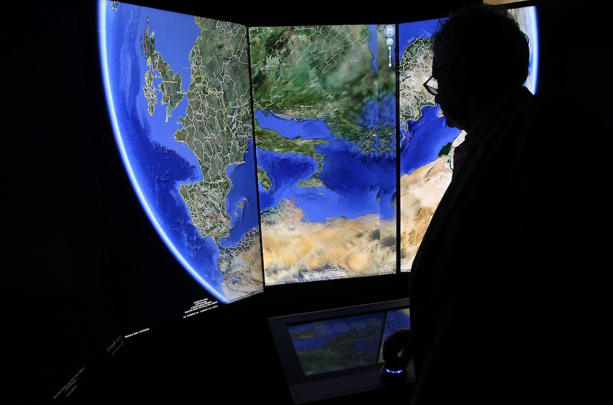 Un visitatore osserva una rappresentazione tridimensionale della Terra mentre utilizza il software Google Earth nel 2012 nella sede di Berlino, in Germania (Adam Berry/Getty Images)