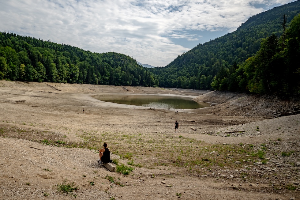 Alcune persone camminano sul fondale del lago Nussensee, in Austria, ormai gravemente ridotto a causa della siccità (Christian Bruna/Getty Images)
