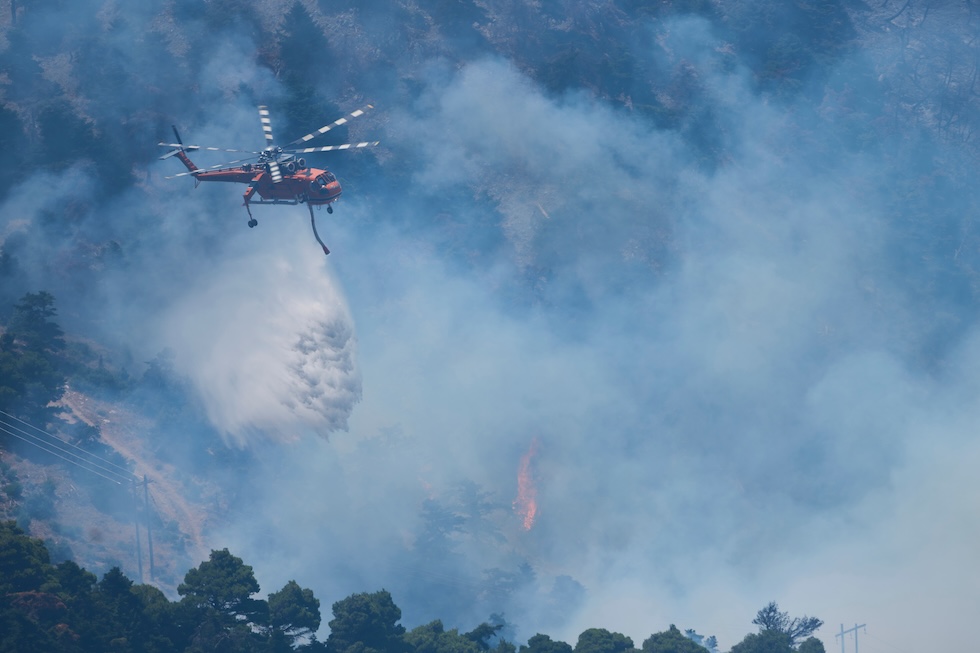 Un elicottero dei vigili del fuoco al lavoro per spegnere un incendio sul monte Kithairon (AP Photo/Petros Giannakouris)
