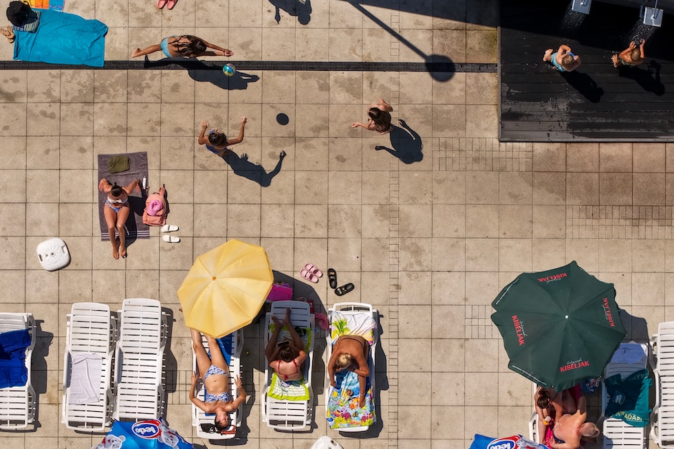 Persone che prendono il sole e giocano a pallavolo alla piscina pubblica Dobrinja (AP Photo/Armin Durgut)
