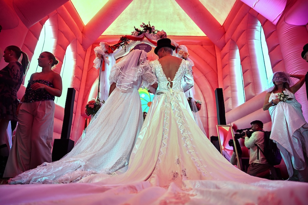 Una coppia si sposa a una cerimonia di matrimonio collettiva organizzata in una cappella gonfiabile, in occasione degli eventi del Pride per celebrare il 25esimo anniversario della legalizzazione del matrimonio tra persone dello stesso sesso (AP Photo/Mouneb Taim)