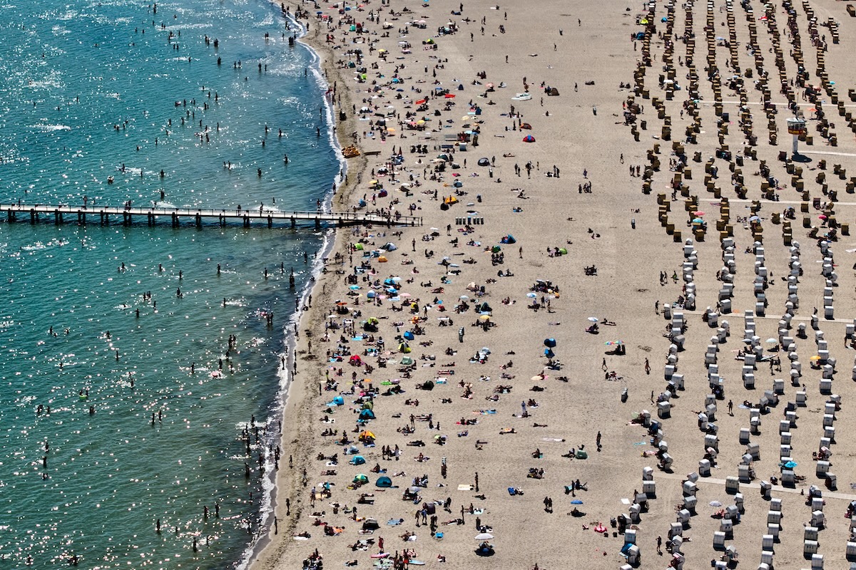 Decine di persone in spiaggia o a fare il bagno nel mar Baltico, domenica (AP Photo/Michael Probst)