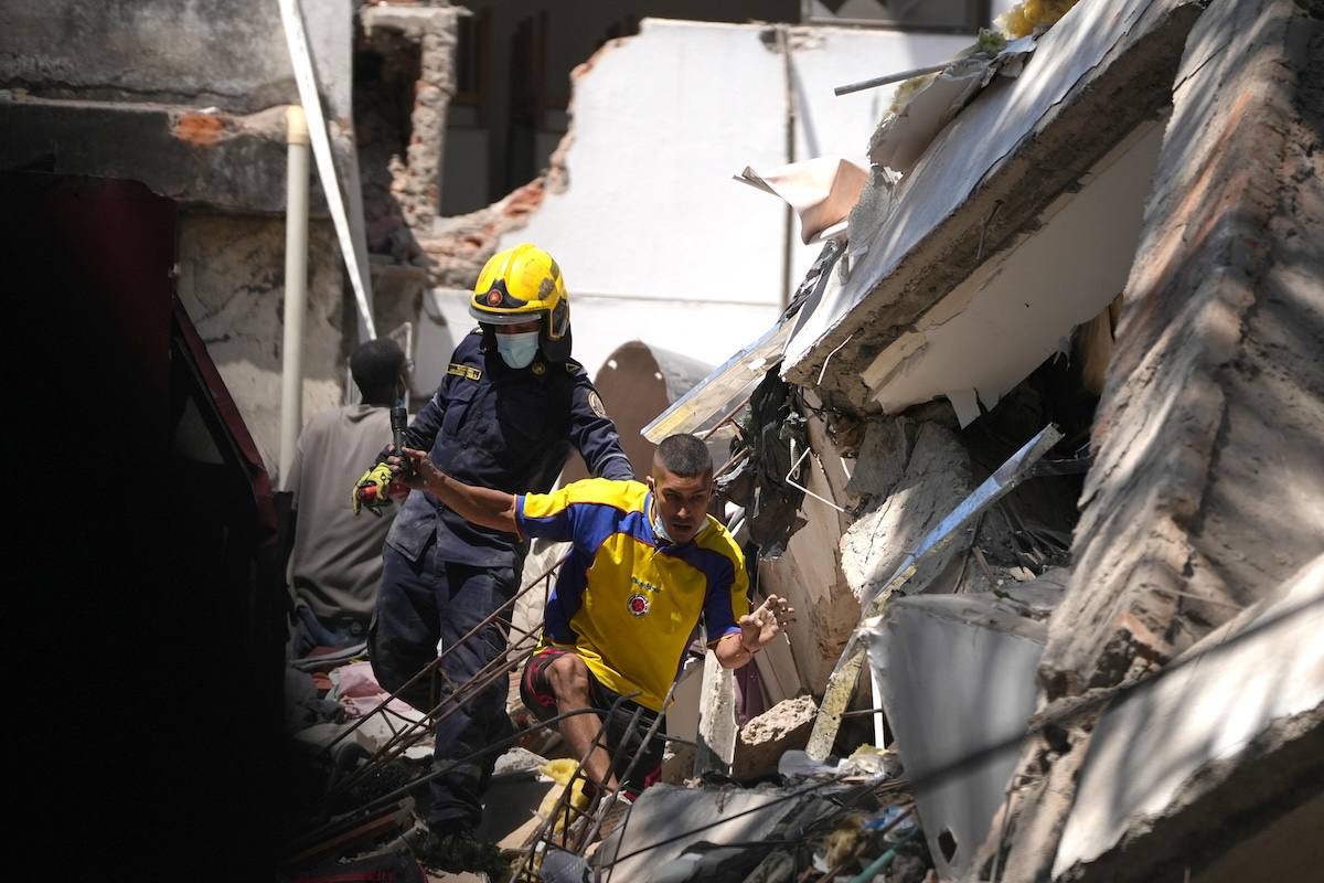 Un pompiere di Cali mentre soccorre una persona in un edificio crollato, il 10 agosto 2026 (EPA/ERNESTO GUZMAN JR)