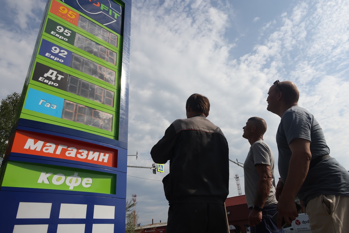 Alcuni uomini guardano i prezzi di un distributore di benzina a Dedovsk, vicino a Mosca, il 7 agosto