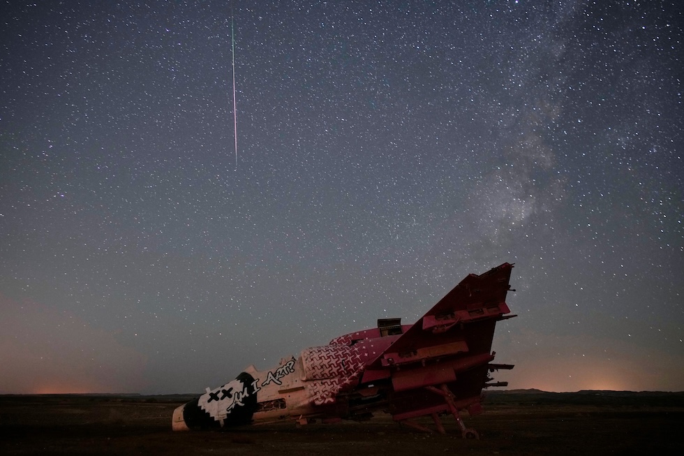 Una meteora nel cielo sopra un aereo da addestramento distrutto; dopo l’eclissi solare c’è stato anche il picco delle Perseidi, lo sciame di stelle cadenti (AP Photo/Ohad Zwigenberg)