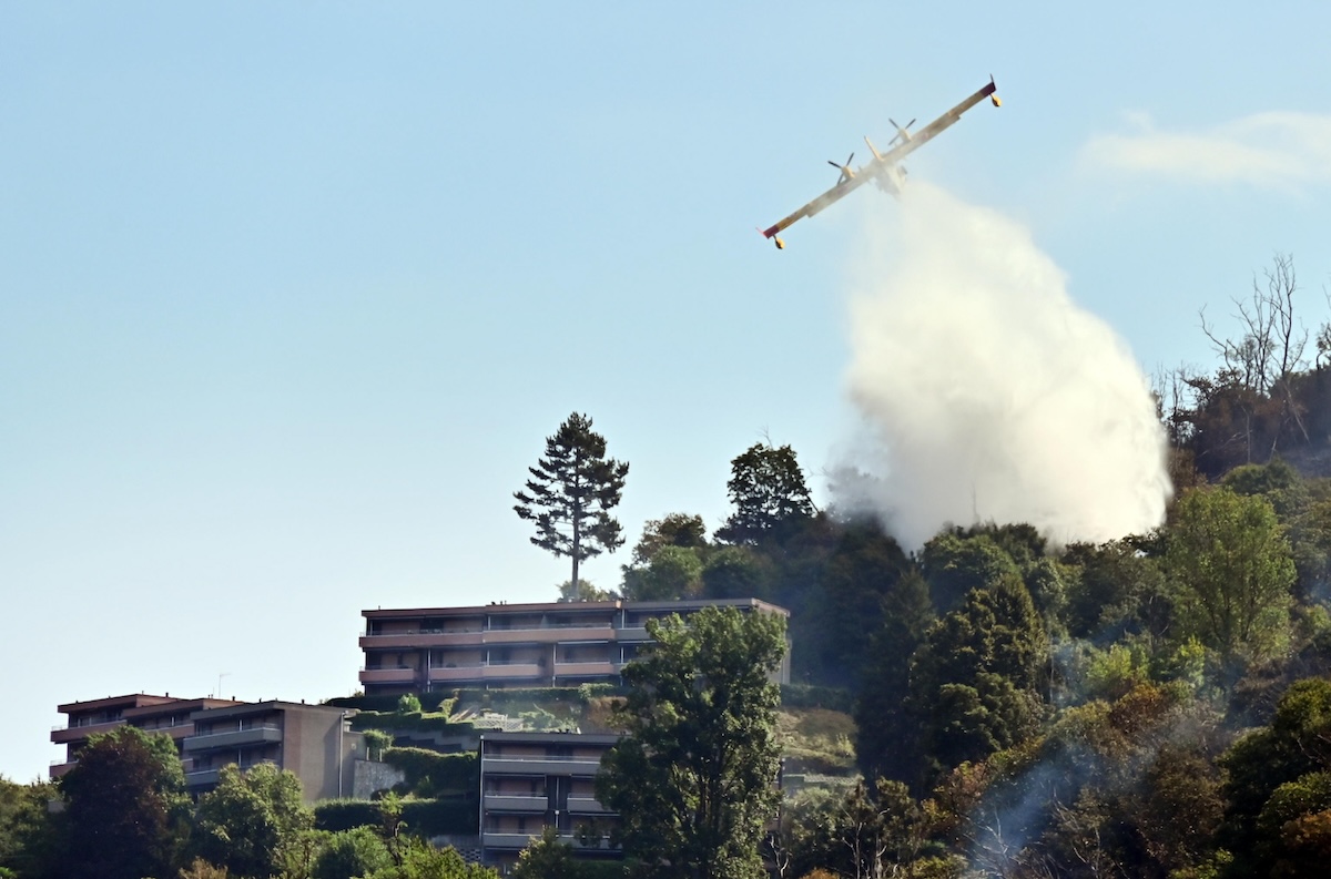 Un Canadair getta acqua sull'incendio sul monte Goj a Como, 14 agosto 2026 (ANSA/FABRIZIO CUSA)