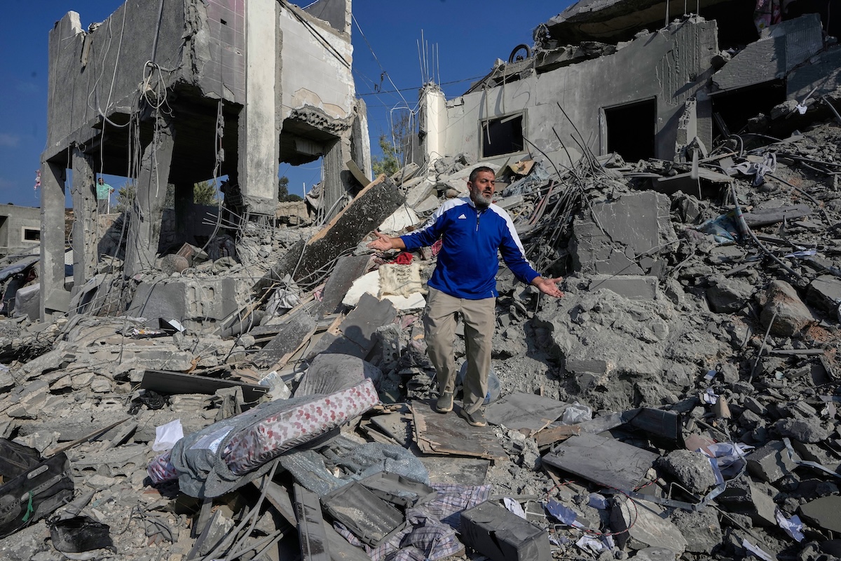 Un uomo tra le macerie di un edificio distrutto da un bombardamento israeliano (AP Photo/Mohammed Zaatari)