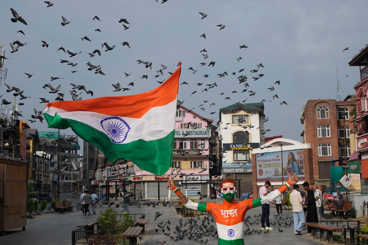 Un uomo con i colori della bandiera dell'India dipinti sul corpo sventola una bandiera del paese nella giornata dell'indipendenza indiana, nel Kashmir indiano. L'India ottenne l’indipendenza dal Regno Unito il 15 agosto del 1947, e il Kashmir è un territorio himalaiano conteso fra India e Pakistan da quasi 80 anni. (AP Photo/Mukhtar Khan)