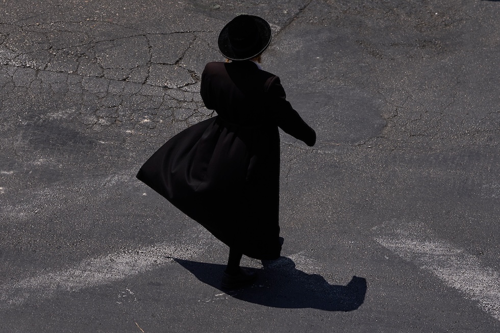 Un uomo ebreo ultraortodosso cammina nel quartiere di Mea Shearim (AP Photo/Ohad Zwigenberg)

