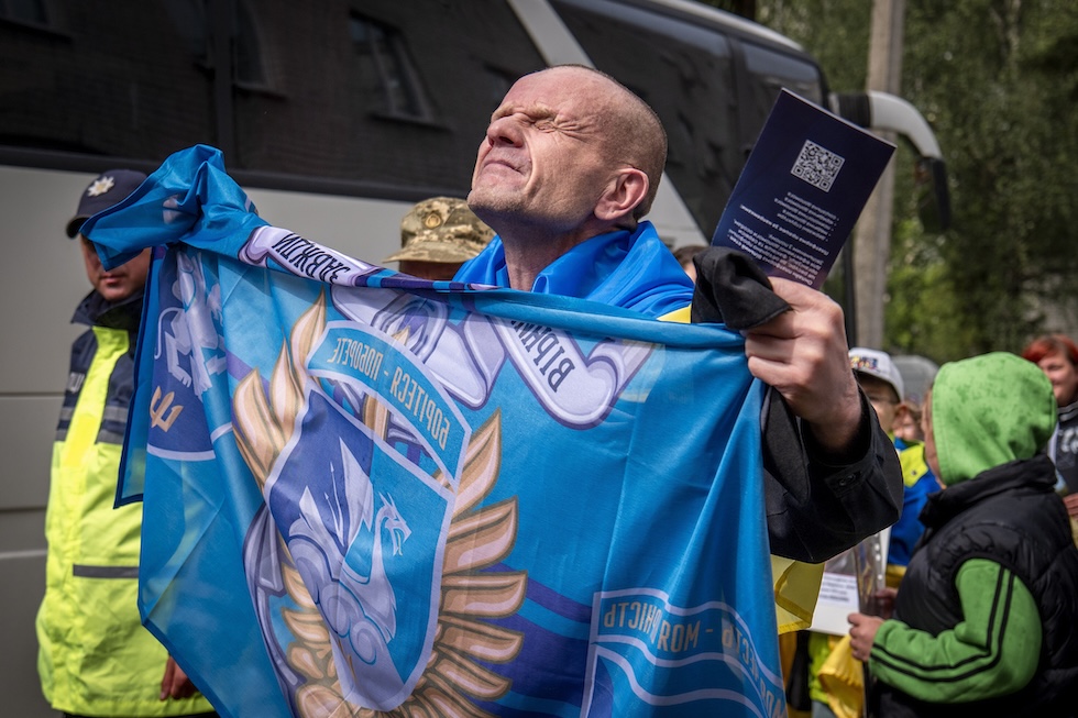 Un soldato ucraino mostra la bandiera della propria unità dopo essere stato liberato in uno scambio di prigionieri di guerra con la Russia (AP Photo/Dan Bashakov)