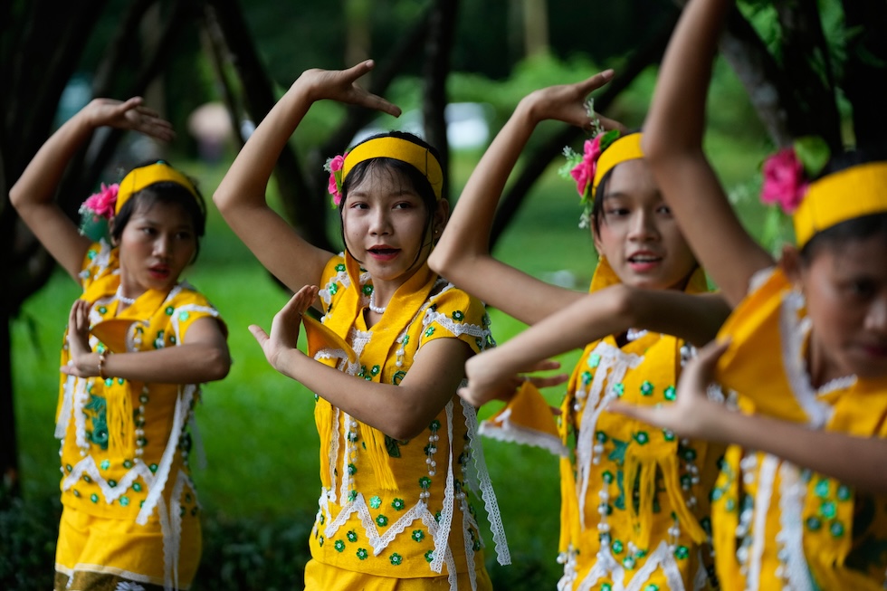 Bambine di etnia Karen, in abiti tradizionali, danzano durante la cerimonia di legatura dei polsi, un rito in cui vengono legati fili bianchi ai polsi come gesto di buon auspicio (AP Photo/Thein Zaw)