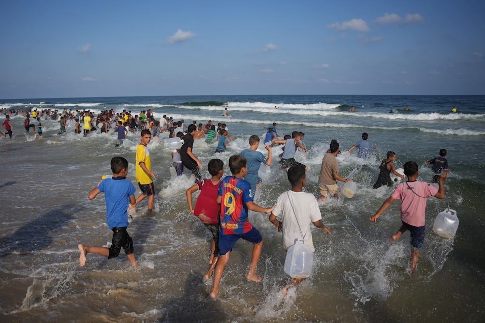 Centinaia di bambini palestinesi partecipano a un evento di nuoto dell’iniziativa "Swimming with Gaza" (AP Photo/Abdel Kareem Hana)