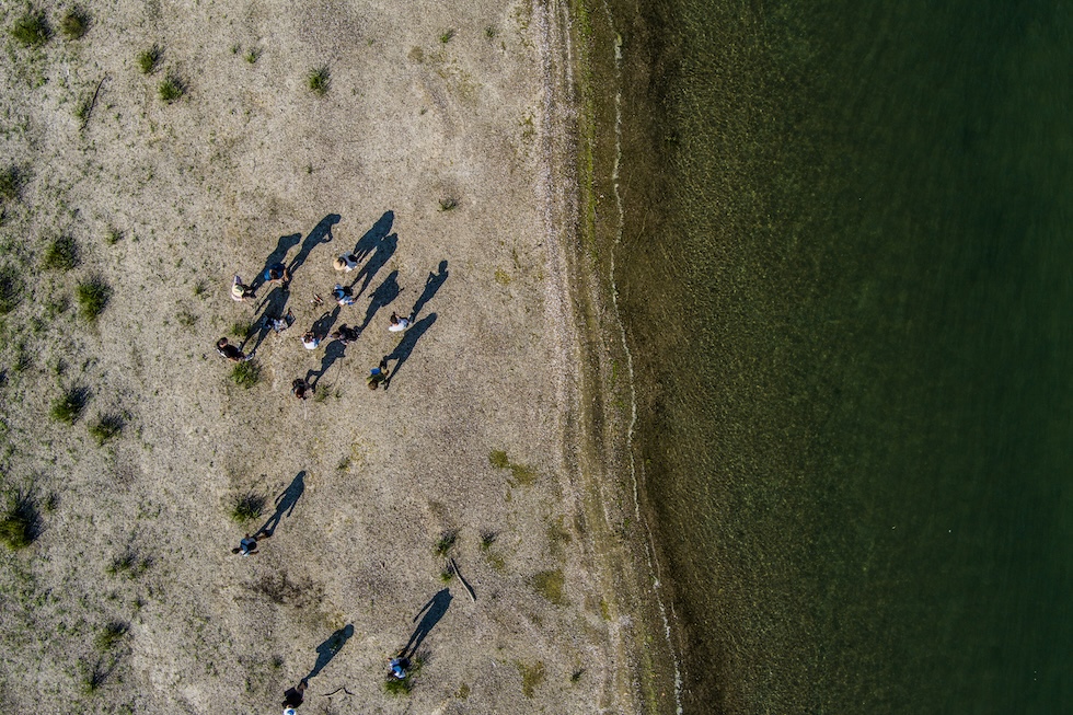 Alcune persone attraversano un tratto di letto del fiume rimasto scoperto a causa del basso livello delle acque del Danubio  (Hristo Rusev/Getty Images)
