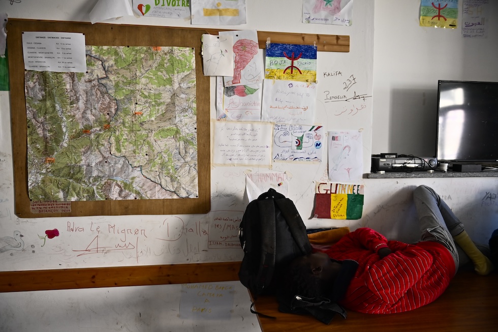 Una mappa e alcune scritte all'interno del rifugio Fraternità Massi di Oulx